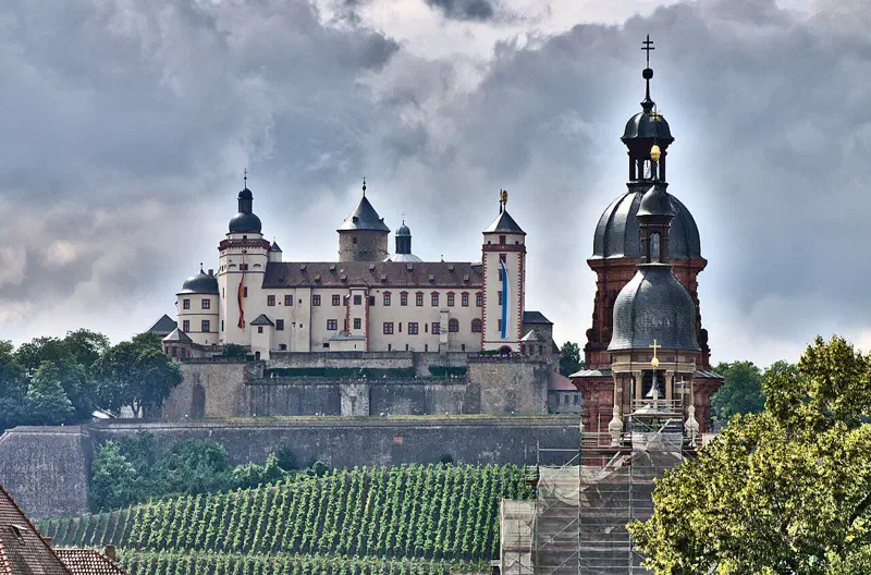 Festung Marienberg über einem Weinberg mit dem Turm der Neubaukirche in Würzburg