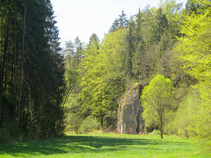 Kletterer und Kalkfelsen im bewaldeten Paradiestal im Frankenjura