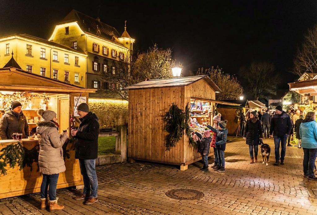 Treuchtlinger Schlossweihnacht: beleuchtetes Stadtschloss und Weihnachtsmarktbuden rund um den Schlossgraben