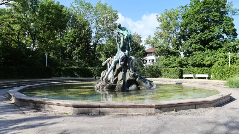 Sintflutbrunnen zwischen Bäumen im Coburger Rosengarten