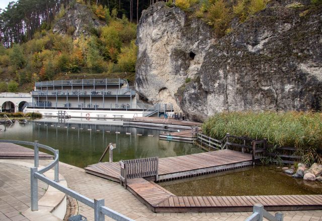 Naturbecken des Felsenbads Pottenstein direkt unter einer hohen Felswand