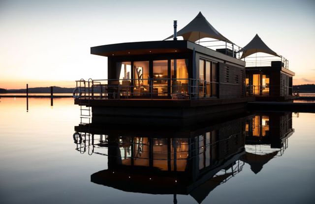 Beleuchtete Wasservillen des Floating Village auf dem Brombachsee bei Sonnenuntergang