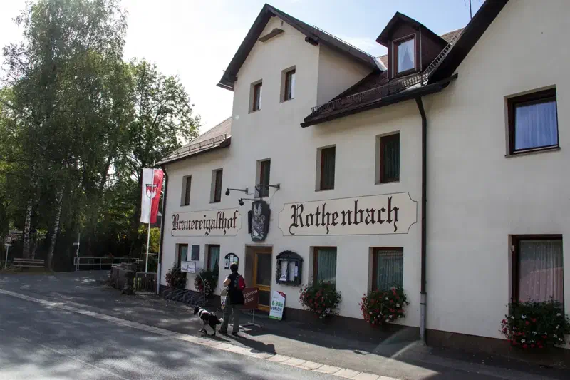 Wanderin vor einem Brauereigasthof am Brauereienweg Aufseß