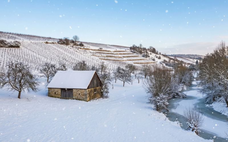 Winterstimmung in Franken mit verschneiten Wäldern und sanften Hügeln.